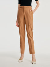 A lady wears cropped pants in camel.